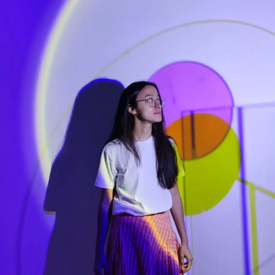 Foto de presentación de María en una exposición de luz con un colorido fondo